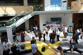 large area with people talk, sun shining in and green and grey sofa area
