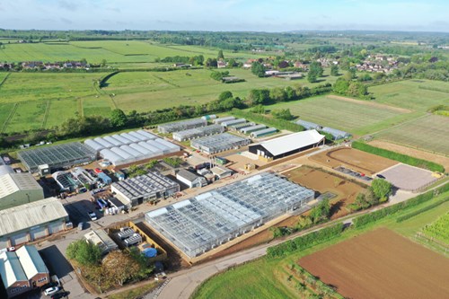 Image of the new greentech hub research facility - open fields and a large glasshouse