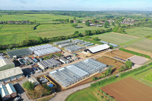 Image of the new greentech hub research facility - open fields and a large glasshouse